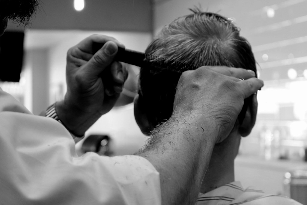 Barber using clippers on the side of a client's head