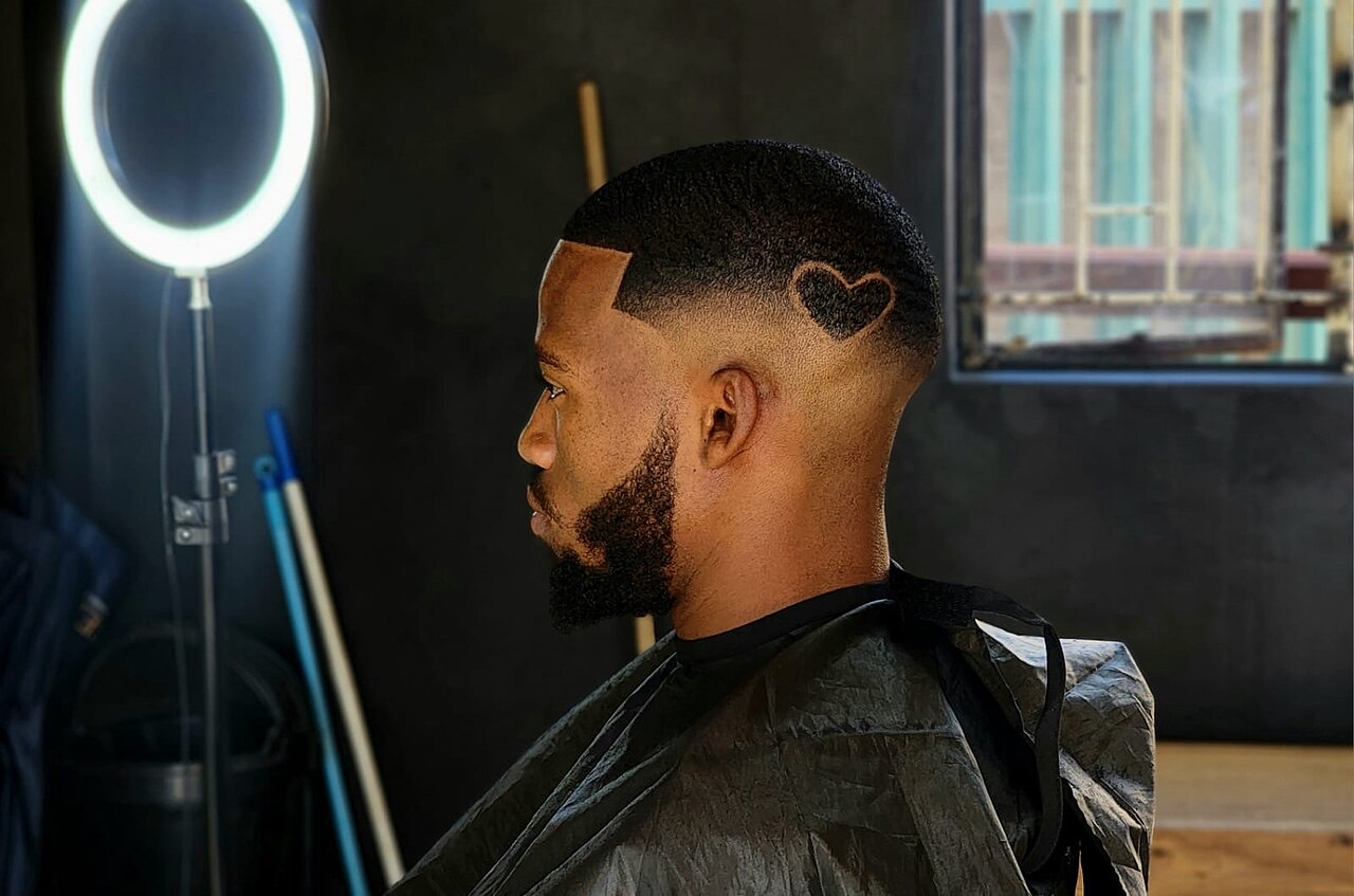 Client with a sharp skin fade and shaped beard