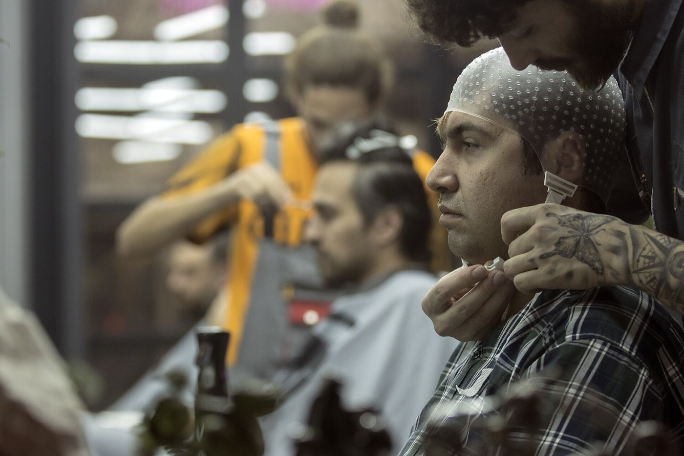 A barber working on a client's beard line
